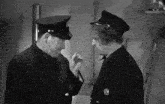 a black and white photo of two men in uniforms