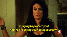 a woman says " i 'm trying to protect you and you 're sitting here doing laundry ! "