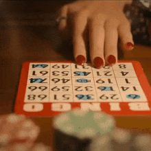 a woman with red nails is playing bingo with a red board