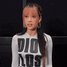 a woman wearing a white shirt that says dio los
