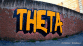 graffiti on a brick wall that says theta in yellow