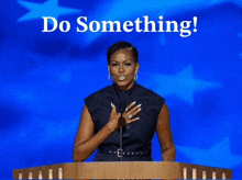 michelle obama stands at a podium with the words do something written above her