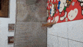 a cat is laying on a wall with a hello kitty rug on it