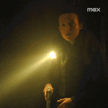 a person is holding a flashlight in a dark room .