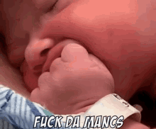 a close up of a baby 's face with the words flick da mancs written above it