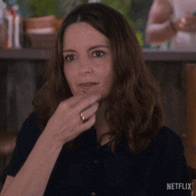 a woman is making a funny face with a netflix logo in the corner