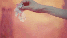 a woman in a white dress is standing in front of a pink wall .