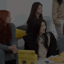 a group of young women are sitting around a table with a yellow box that says ' nintendo switch ' on it