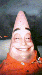 patrick star from spongebob squarepants is smiling for the camera .