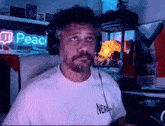 a man wearing headphones and a shirt that says nerds looks at the camera