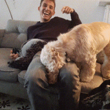 a man sitting on a couch with two dogs