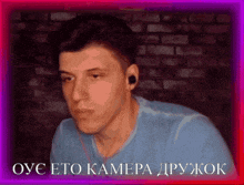 a man wearing ear buds and a blue shirt with the words oyc eto kamera on the bottom