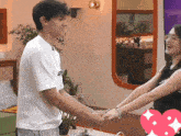 a man and a woman are holding hands in a room