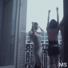 two women are standing on a balcony and the letters ms are on the bottom of the image
