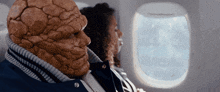 a man with a stone face is sitting next to a woman