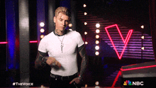 a man in a white shirt is dancing in front of a neon sign that says nbc on it