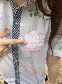 a person pointing at a shirt that says " ngo nam "