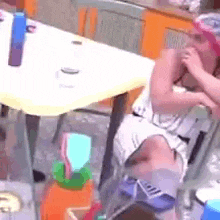 a person is sitting at a table with a bottle of water on it .