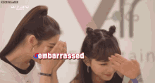two girls covering their faces with their hands and the word embarrassed in red