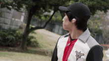 a man wearing a baseball cap and a jacket that says ' wings ' on it