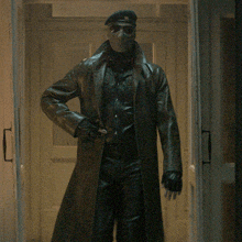 a man wearing a mask and sunglasses walks through a hallway