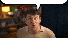 a man is making a surprised face with a speech bubble in the background .