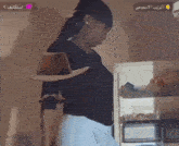 a woman wearing a cowboy hat stands next to a refrigerator