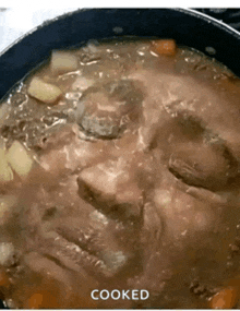 a close up of a pot of soup with a face in it and the words cooked below it