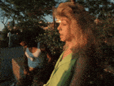 a man in a white tank top is standing next to a woman in a green tank top