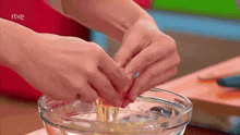 a person is cracking an egg into a bowl with rtve written on the bottom
