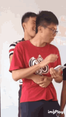 a man wearing a red shirt with the letter s on it