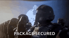 a group of soldiers are standing in a room with the words `` package secured '' written on the screen behind them .