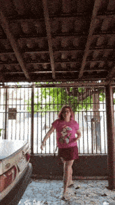 a woman in a pink minnie mouse shirt is dancing
