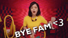 a woman in a yellow shirt is sitting in a chair with the words `` bye fam '' written on it .