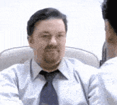 a man with a beard wearing a tie looks at another man