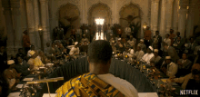 a man stands in front of a long table with a netflix logo on it
