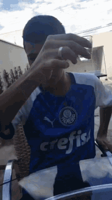 a man wearing a blue and white crefis shirt