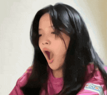 a girl with her mouth open wearing a pink shirt that says round