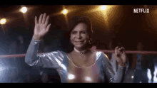 a woman in a rainbow top is waving her hand in a netflix advertisement