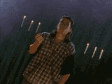 a green power ranger is standing in the rain with a bunch of sticks in his hand .