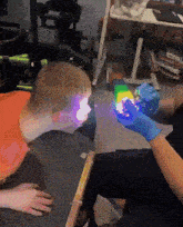 a person wearing blue gloves is holding a rainbow colored toy