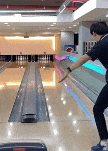 a man throws a bowling ball in a bowling alley that has the number 12 on it