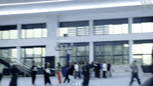 a group of people are standing in front of a basketball hoop with the letters zky on the bottom right