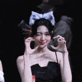 a woman wearing a cat ear headband is making a peace sign with her hands