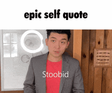 a man in a suit and red shirt stands in front of a sign that says epic self quote stoodid