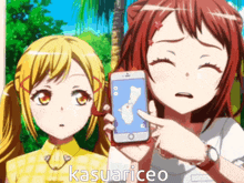 two anime girls are standing next to each other and one is pointing at a cell phone that says kasuariceo on the bottom
