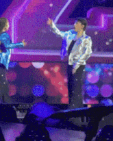 a couple of people standing on a stage with one pointing
