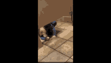 a young boy is laying on the floor in a bathroom