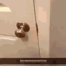 a close up of a door knob on a door with a crack in the wall .