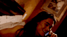 a woman with long hair is talking on a cell phone